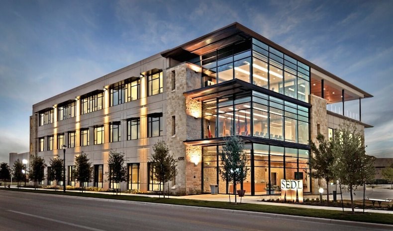 A modern office building with glass windows and multiple floors.